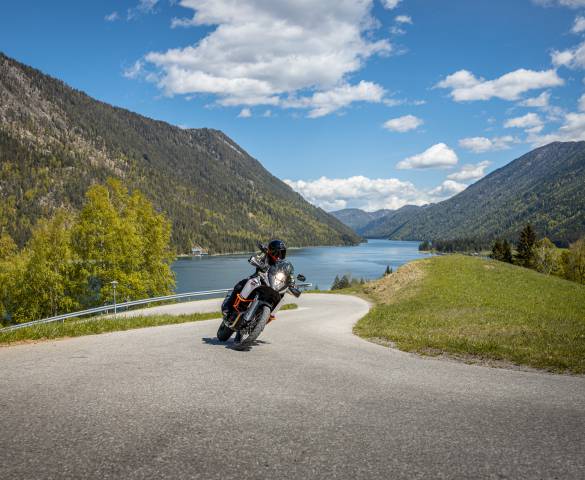 Motorradfahrer mit Blick auf Bergsee in Österreich