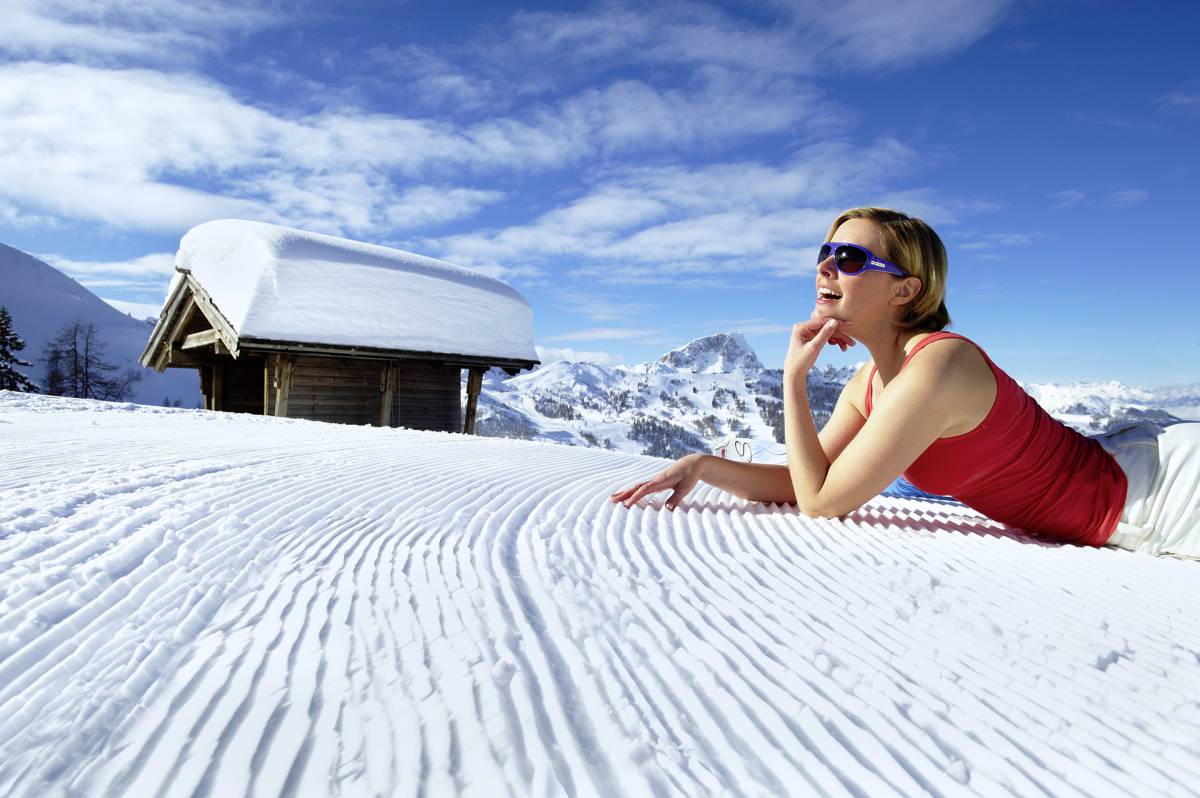 Frau liegt auf Skipiste in Skifahrer in Nassfeld in Kärnten